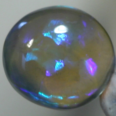 SOLID CRYSTAL OPAL High dome with blue and purple hues throughout the transparent body